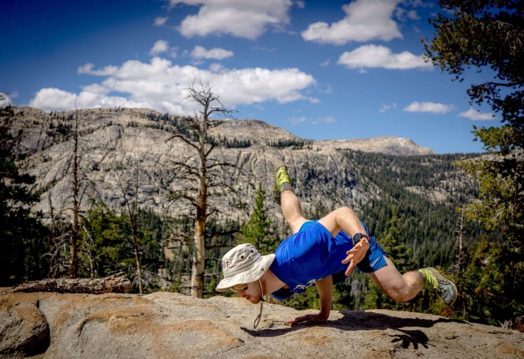 man doing yoga on mountain