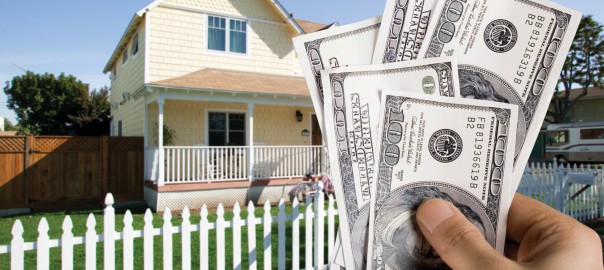 money in hand with house in background